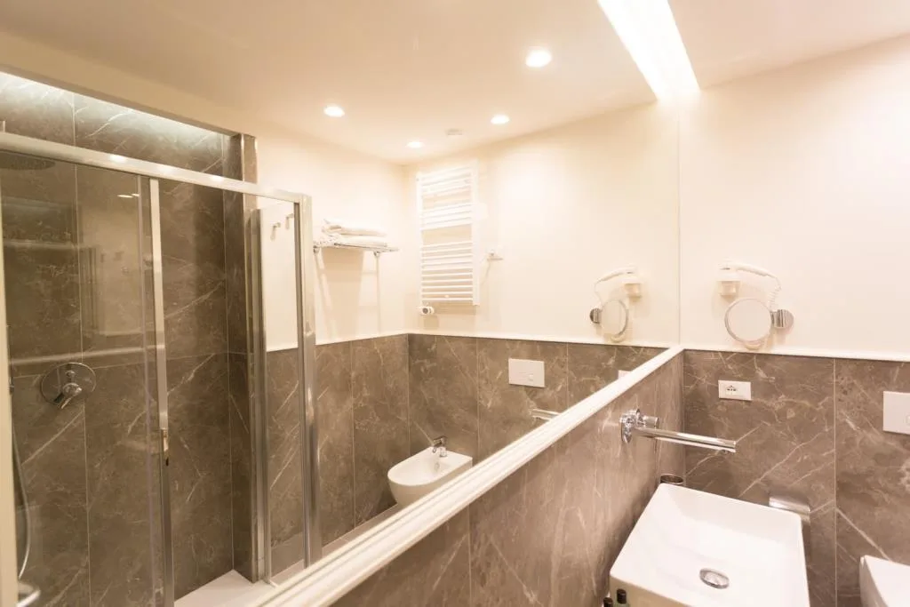 Bagno moderno con doccia, bidet e rivestimento in marmo