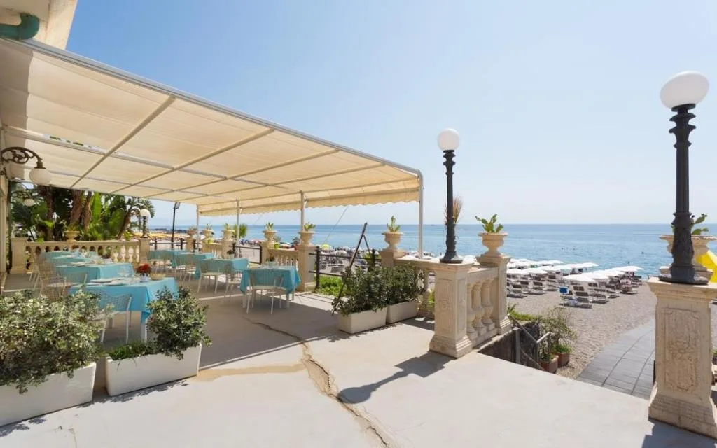 Terrazza esterna con tavoli e vista sulla spiaggia