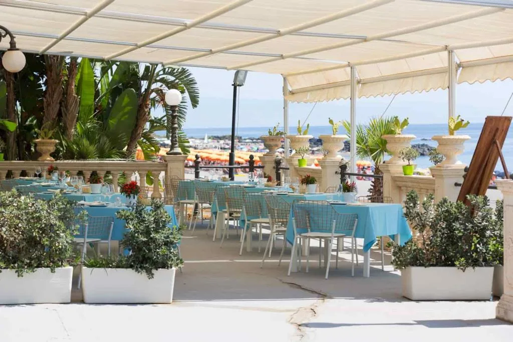 Terrazza ristorante con piante e vista sulla spiaggia