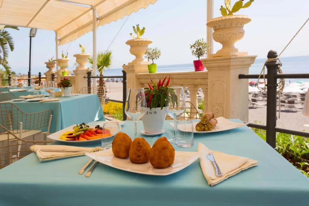Piatto di arancini su tavolo con vista mare