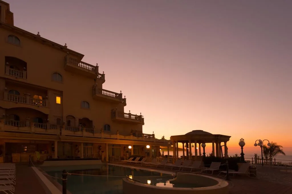 Esterno dell'hotel con piscina al tramonto