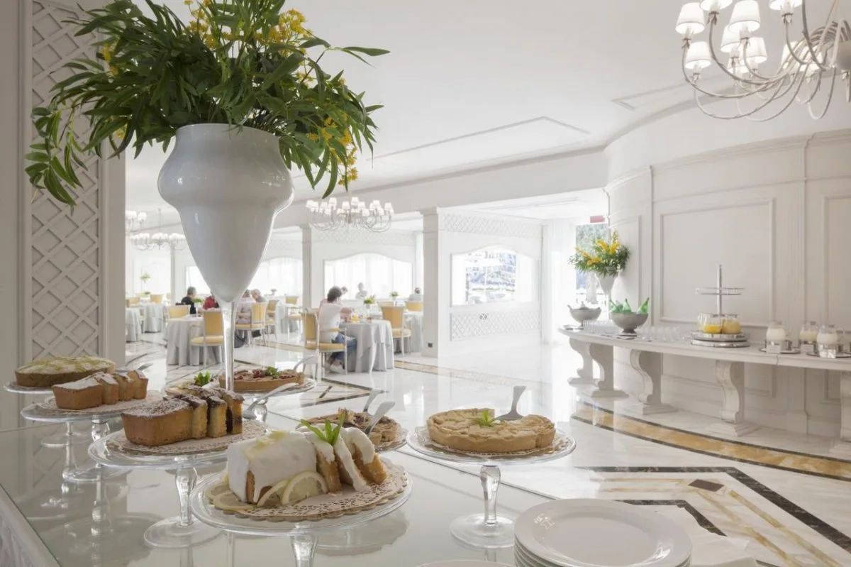 Buffet di dolci e torte nella sala colazioni luminosa con lampadari eleganti
