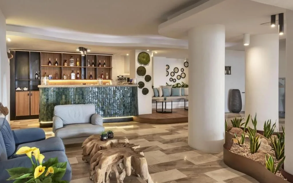 Lobby con area lounge, bar in ceramica e piante decorative