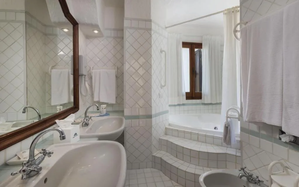 Bagno con doppio lavabo e vasca idromassaggio piastrellata