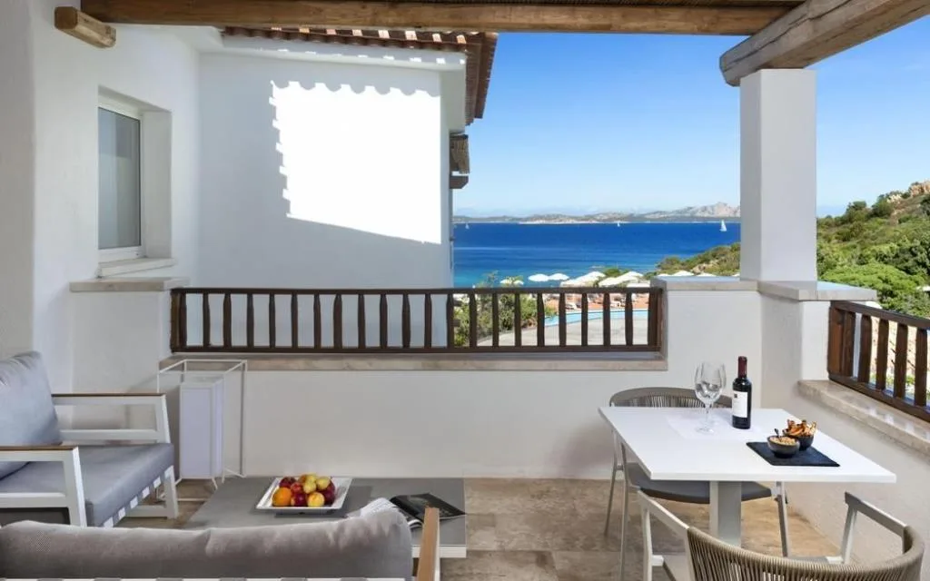 Terrazza privata con tavolo e vista panoramica sul mare e piscina