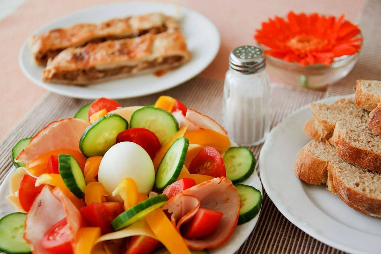 Piatto di affettati e verdure fresche con pane per la colazione